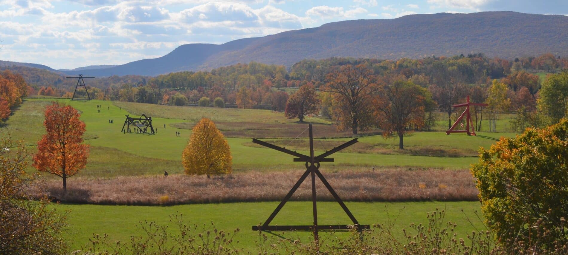 View of large sculptures among rolling hills and trees at Storm King Art Center.
